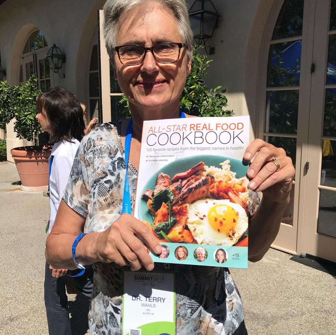 Dr. Terry Wahls holding up the All Star Real Food Cookbook