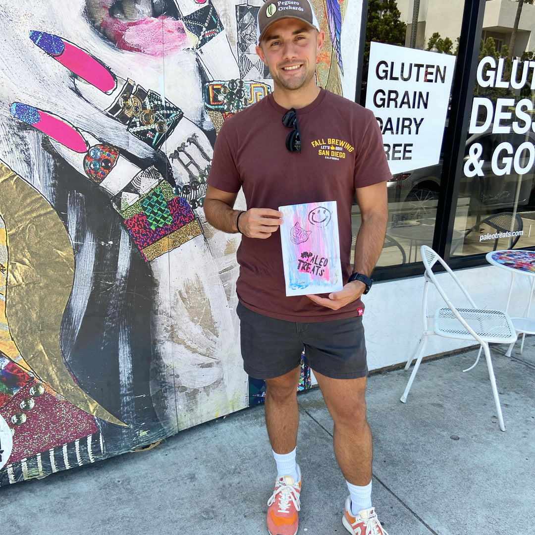 Baller bread man holds up bag with keto bread inside in front of san diego store.