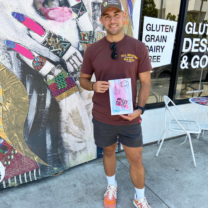 Baller bread man holds up bag with keto bread inside in front of san diego store.