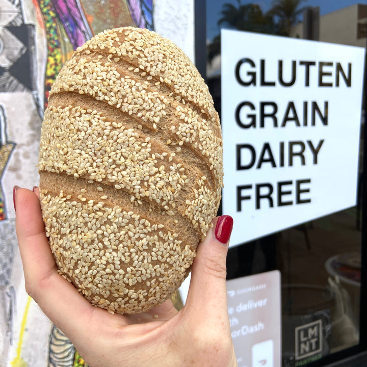 Baller bread womans hand holds up gluten free grain free dairy free bread.