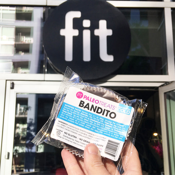 Bandito hand holding up paleo dessert in front of fit gym downtown san diego.