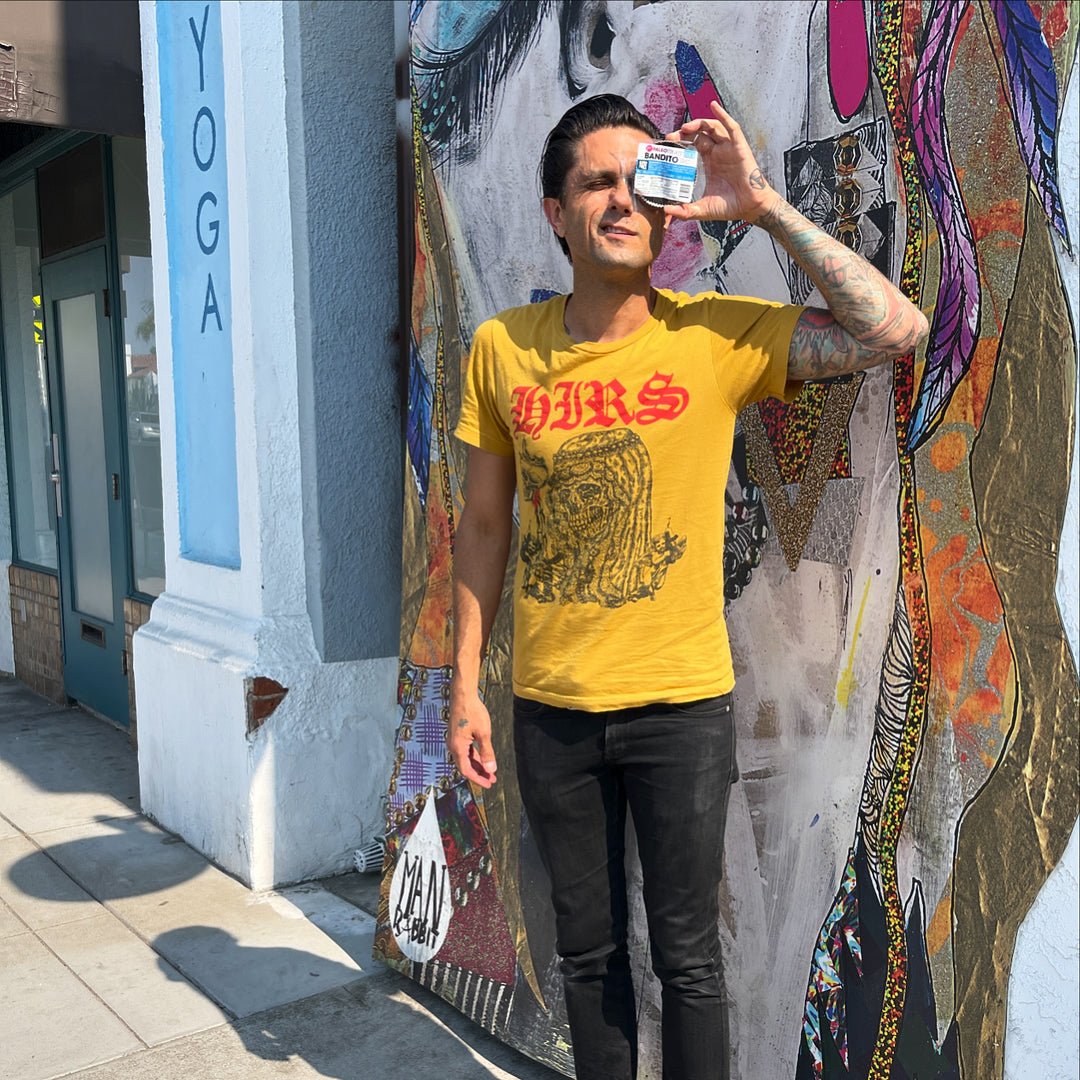 Justin Pearson rocker from san diego holds up an almond butter chocolate cup in front of store.