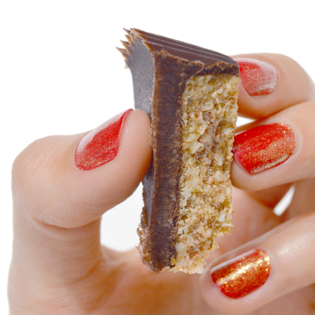 Bandito womans hand holding slice of grain free peanut butter chocolate cup.