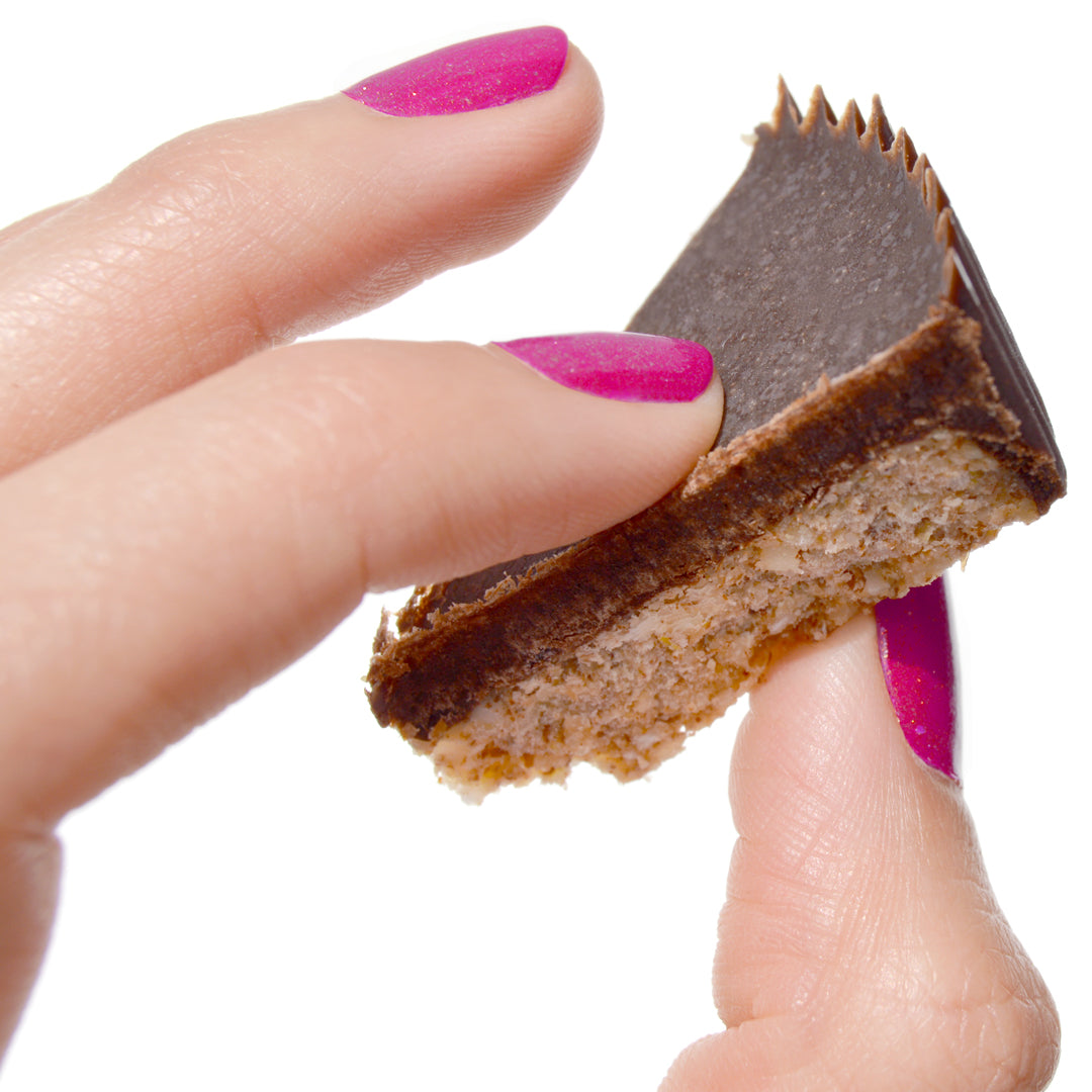 Bandito womans thumb and finger holding bandito piece mini paleo pie.