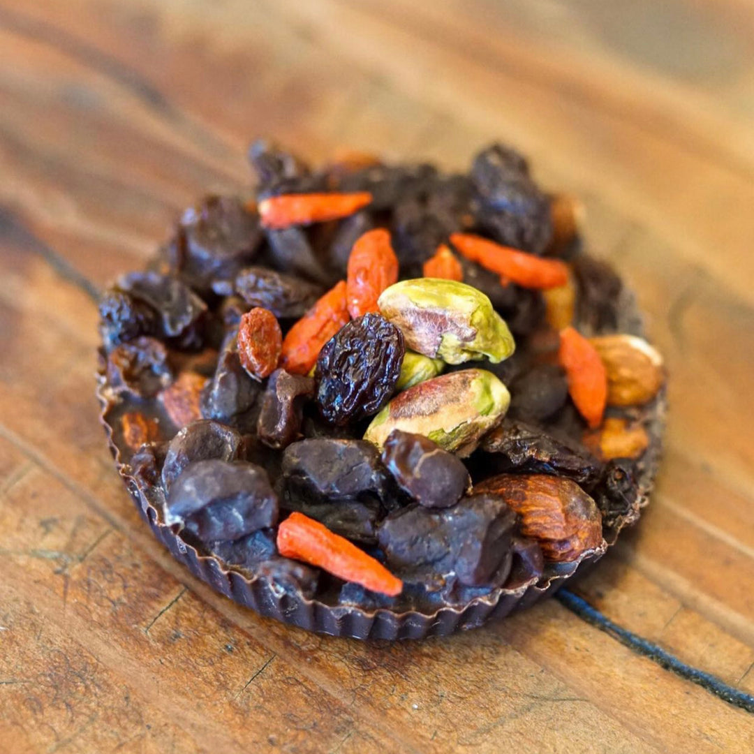 Cacao now top down shot goji berries pistachios in chocolate bar by Paleo Treats.