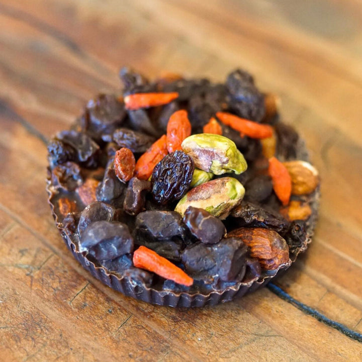 Cacao now top down shot goji berries pistachios in chocolate bar by Paleo Treats.
