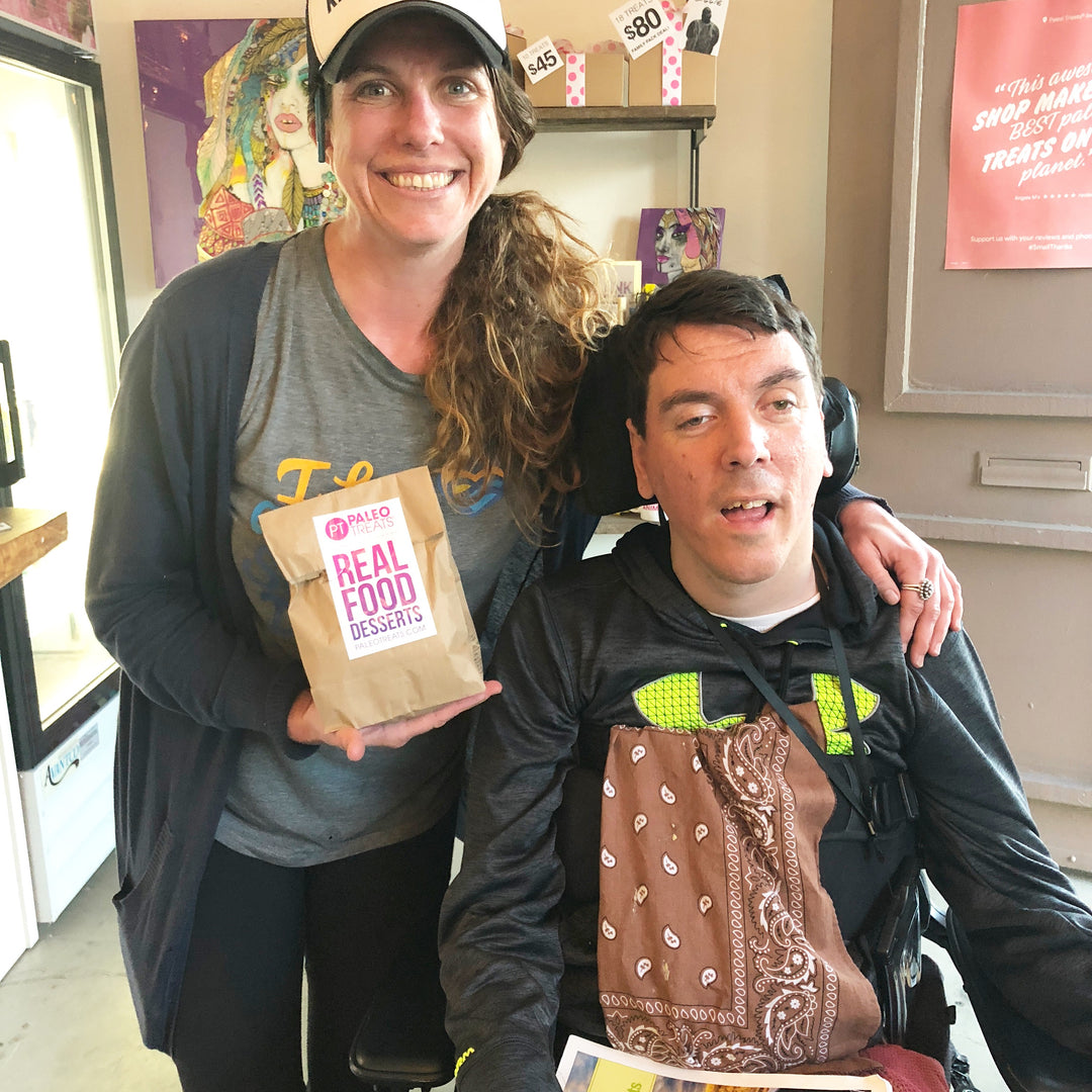 Happy customer in wheelchair with sampler bag of paleo treats mustang bar.