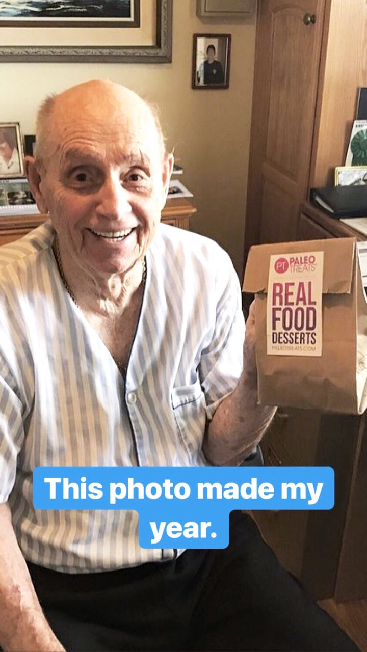 Older man holding up sampler bag of paleo desserts.