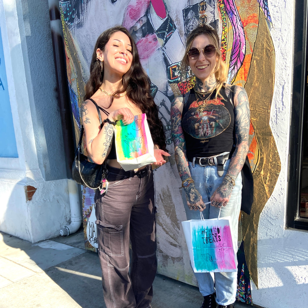 Paleo desserts for a crowd two women with bags full of paleo treats.