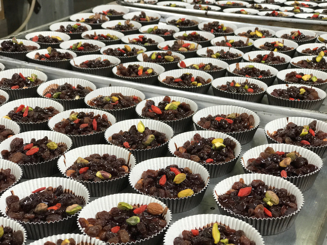 Rows and rows of paleo chocolate bars being made with goji berries and pistachios by Paleo Treats.