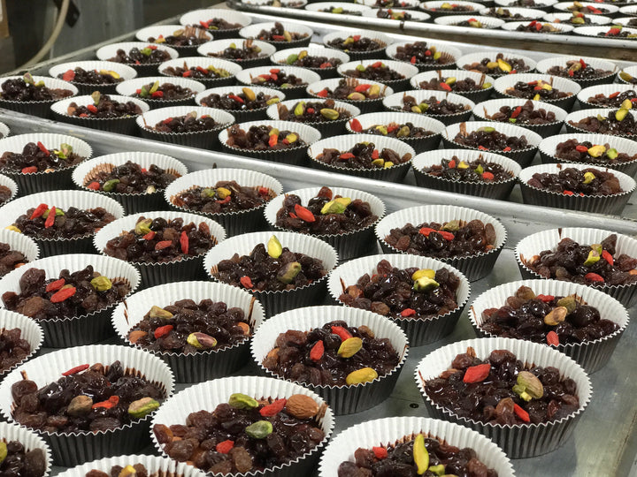 Rows and rows of paleo chocolate bars being made with goji berries and pistachios by Paleo Treats.