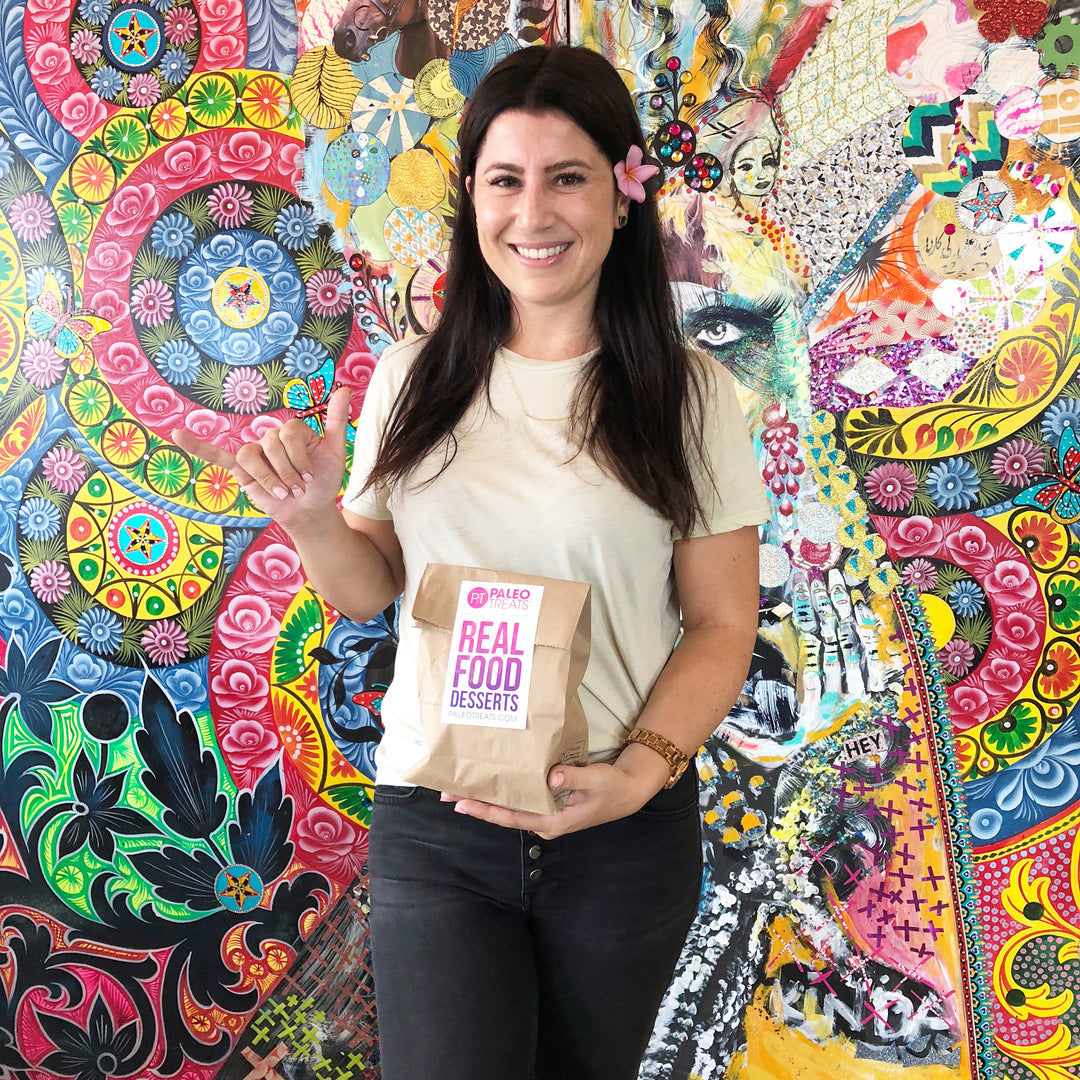 Small stack sampler happy woman in normal heights store with bag of paleo treats sampler.