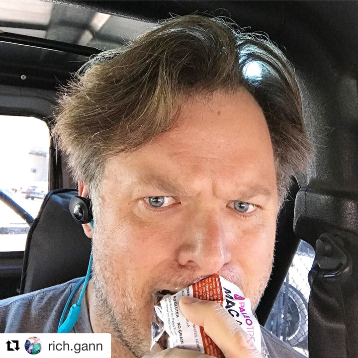 Uncertain man in car eating paleo macaroon.