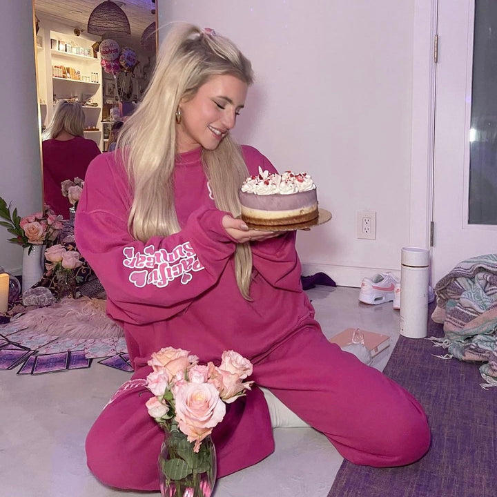 Vegan gf cake woman in pink clothing smiling at triple berry gluten free cake.