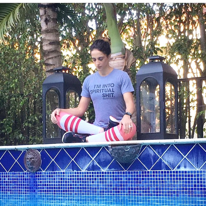 Woman meditates with spiritual shit t shirt.