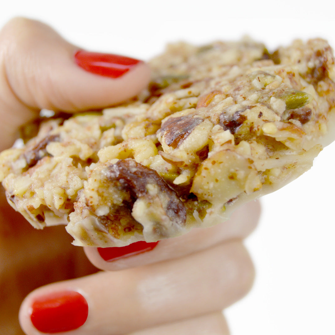 Womans hand holding mustang bar a paleo oatmeal raisin cookie granola bar by paleo treats.